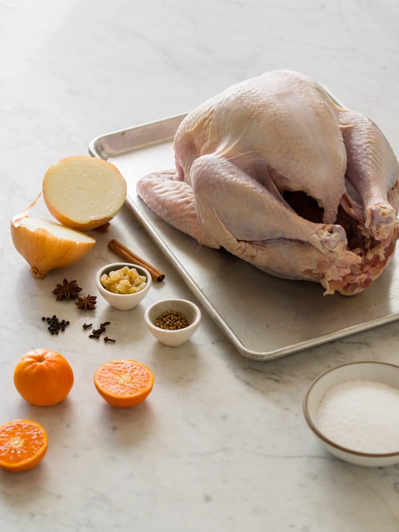 Ingredients for citrus and herb roasted turkey on a marble countertop. 