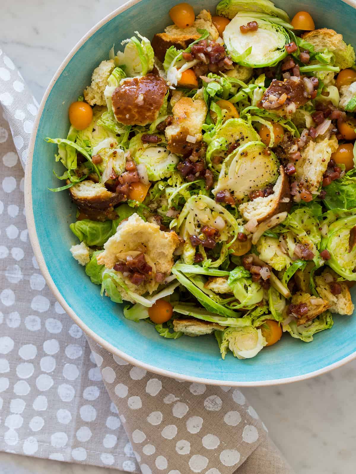 Shaved brussels sprouts salad in a blue bowl.