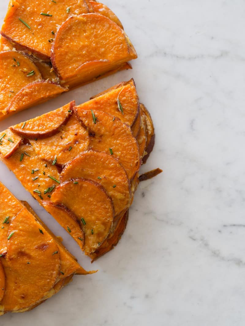 A close up of sweet potato and rosemary gratin sliced into a triangle serving.