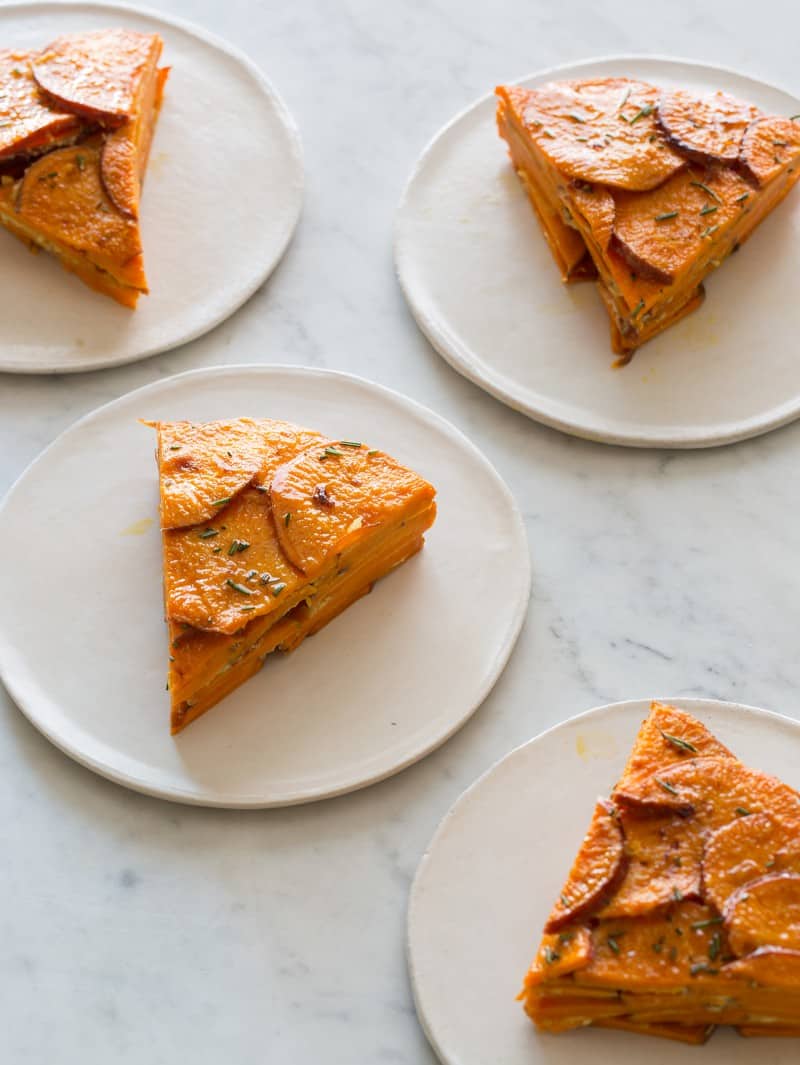 Sweet potato and rosemary gratin slices on plates.