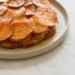 A close up of sweet potato and rosemary gratin on a plate.