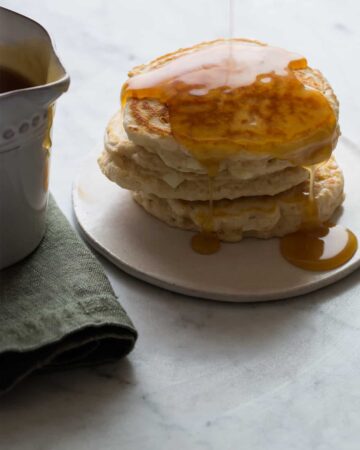 A close up of apple cinnamon pancakes with brown sugar buttermilk syrup.
