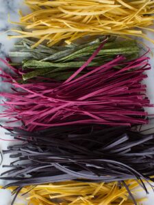 A colorful variety of homemade pastas lined up.