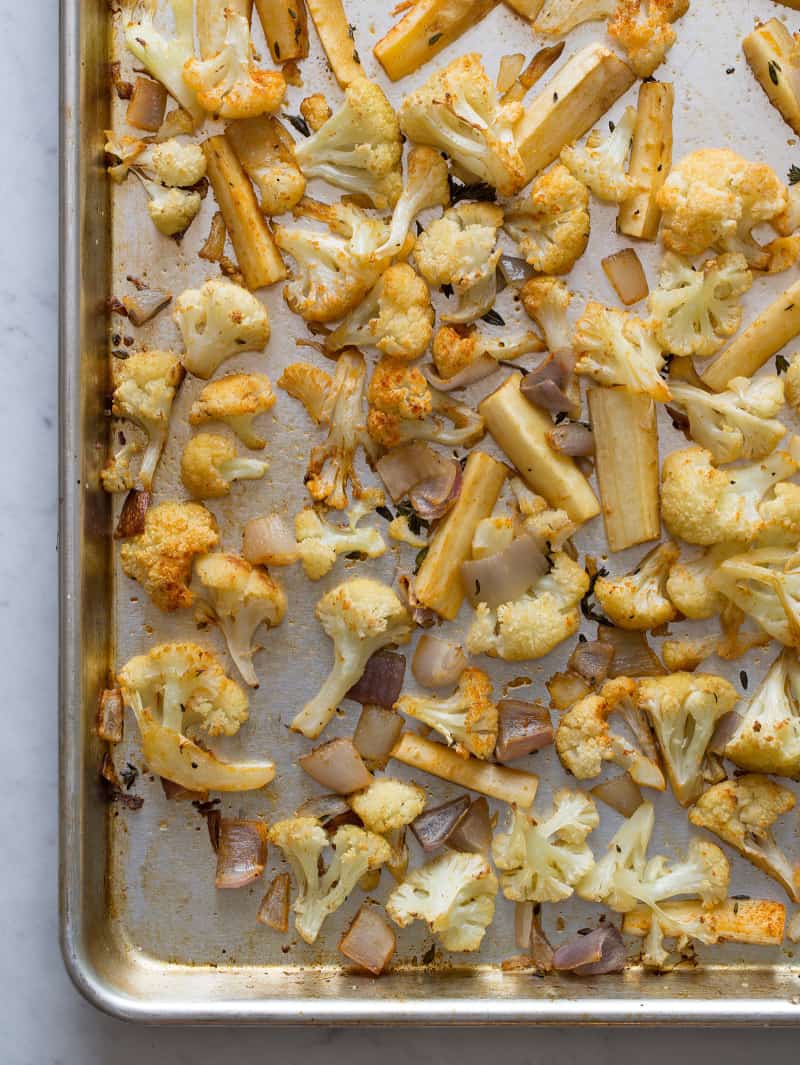 A close up of a sheet pan of roasted cauliflower and parsnips.