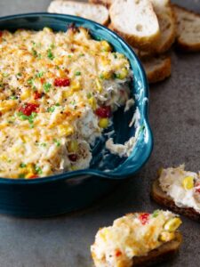 A close up of a dish of hot crab dip with dipped crostini.