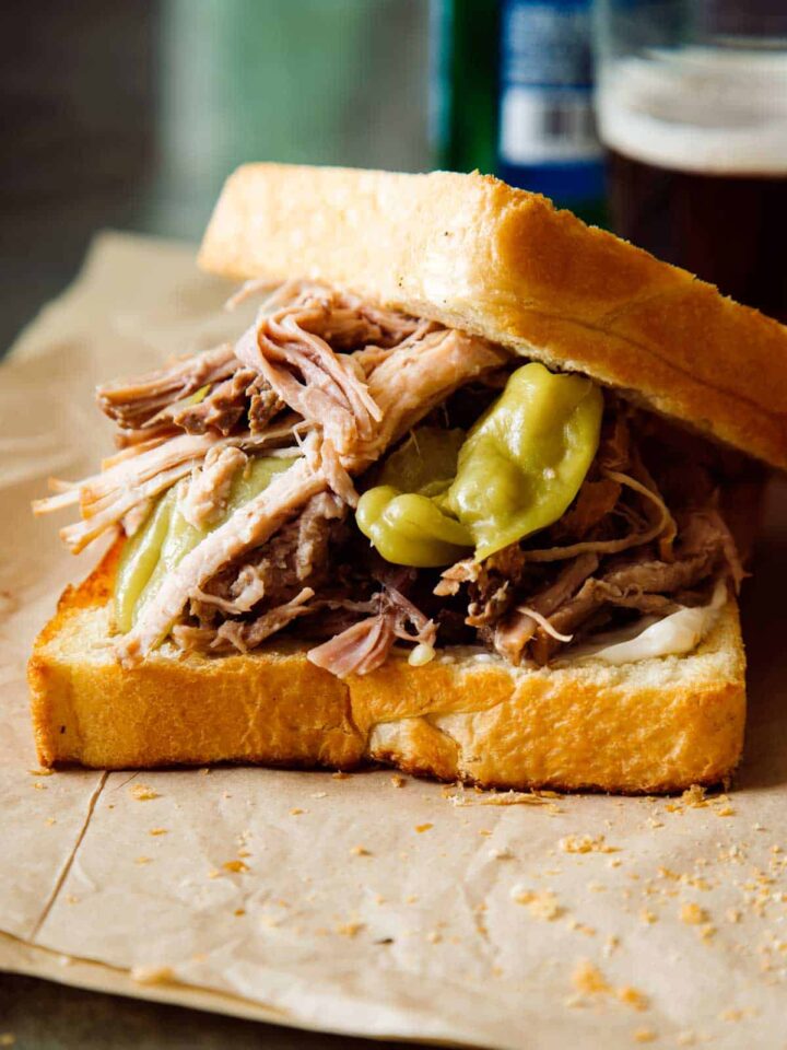 A close up of a slightly opened slow cooker pickled pulled pork sandwich.