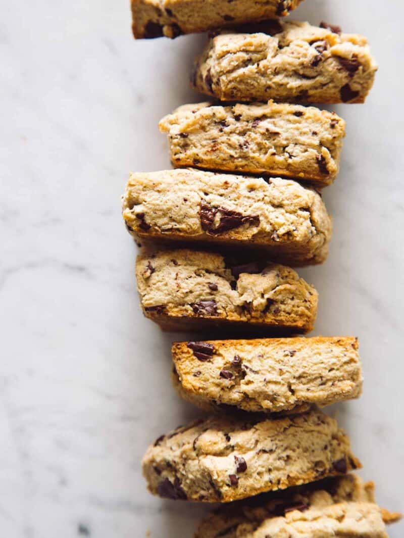 A close up of stacked chocolate chunk and cinnamon scones.