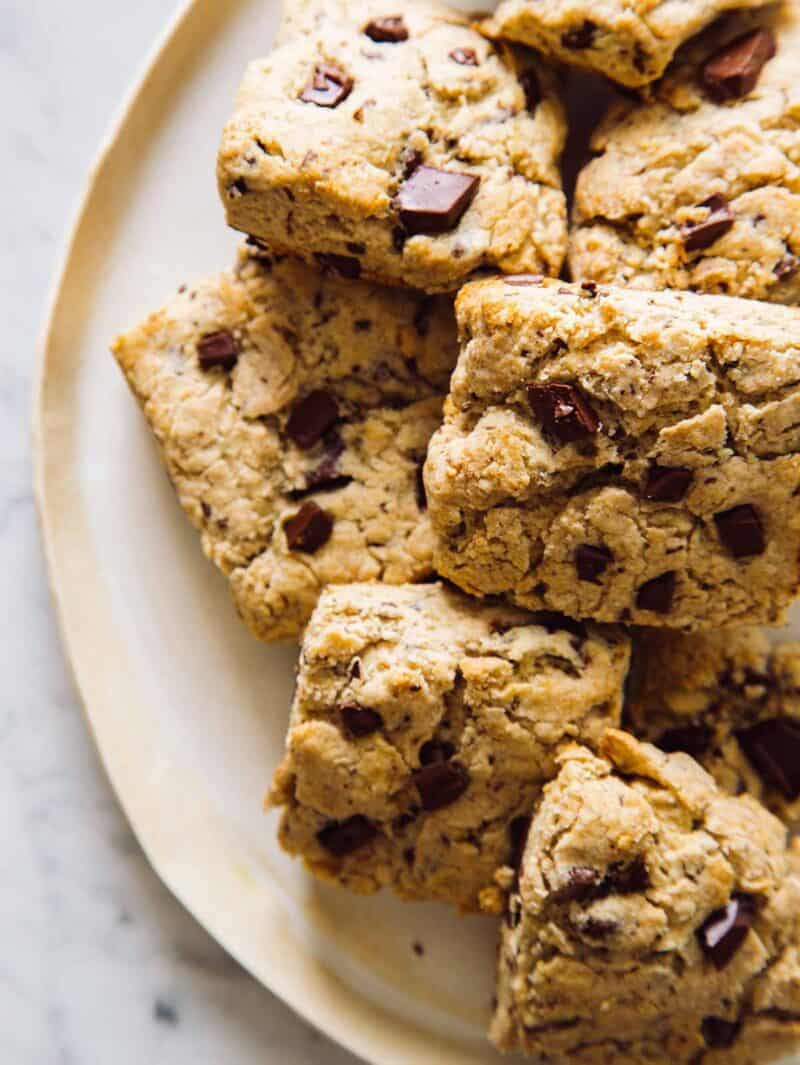 A plate full of chocolate chunk and cinnamon scones.