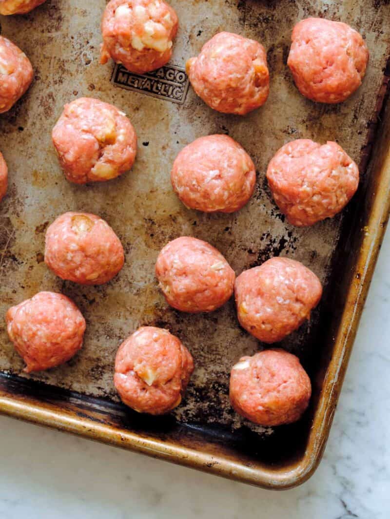 A sheet pan of ginger garlic meatballs ready to bake.