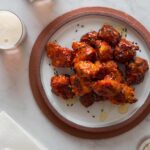 A plate of Korean fried chicken nuggets with drinks.