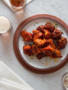 A plate of Korean fried chicken nuggets with drinks.