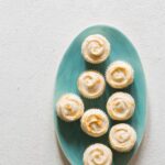 A green platter of butter cupcakes with grapefruit buttercream.