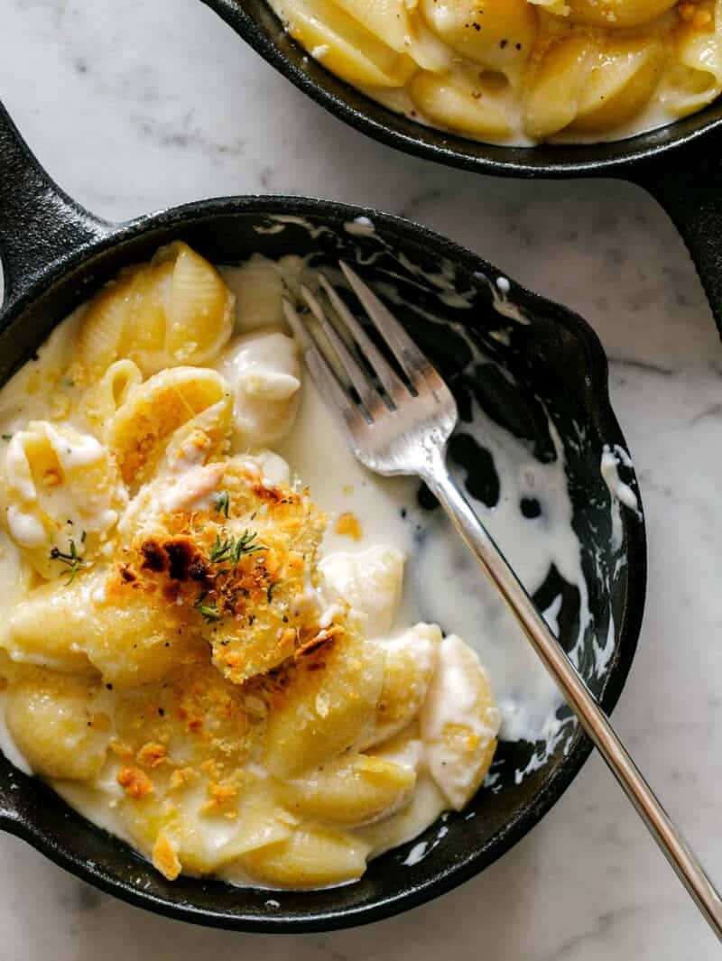 A close up of creamy skillet mac and cheese, half eaten with a fork.