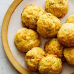 A close up of havarti and green onion cornmeal drop biscuits on a plate.