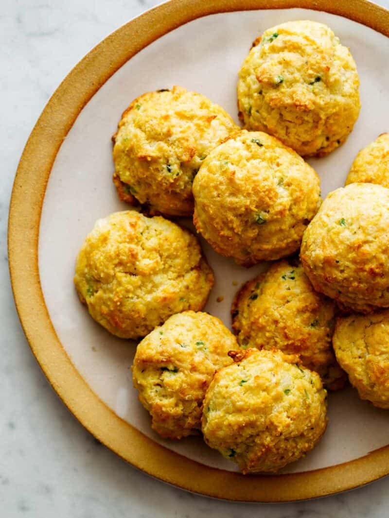 A close up of cornmeal and jalapeño cheddar biscuits on a plate.