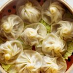 Shanghai Soup Dumplings in a steamer with cabbage.