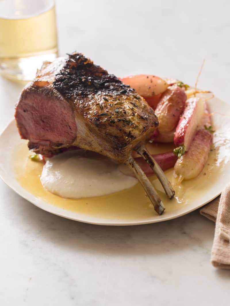 A plate of grilled rack of lamb with creamy feta horseradish sauce, roasted radishes.
