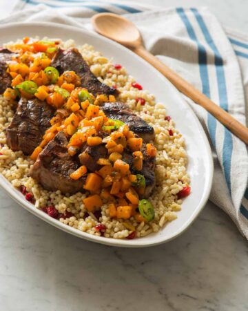 A platter of harissa grilled lamb chops with fresh apricot serrano salsa on couscous.