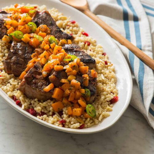 A platter of harissa grilled lamb chops with fresh apricot serrano salsa on couscous.