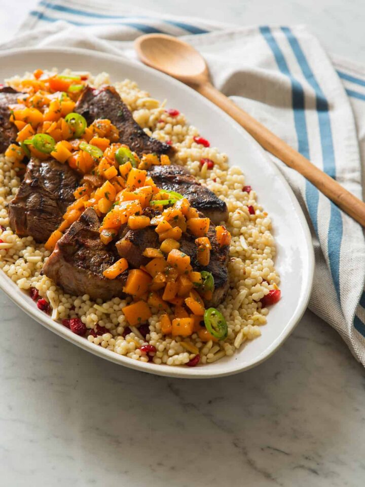 A platter of harissa grilled lamb chops with fresh apricot serrano salsa on couscous.