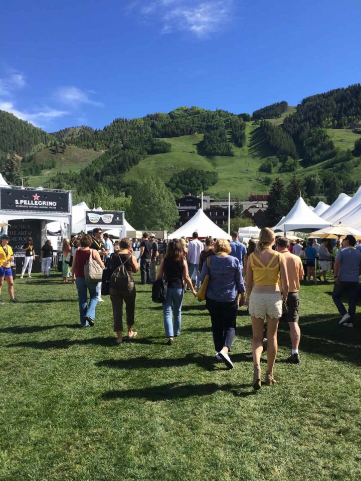 A group of people walking through an outdoor food festival.