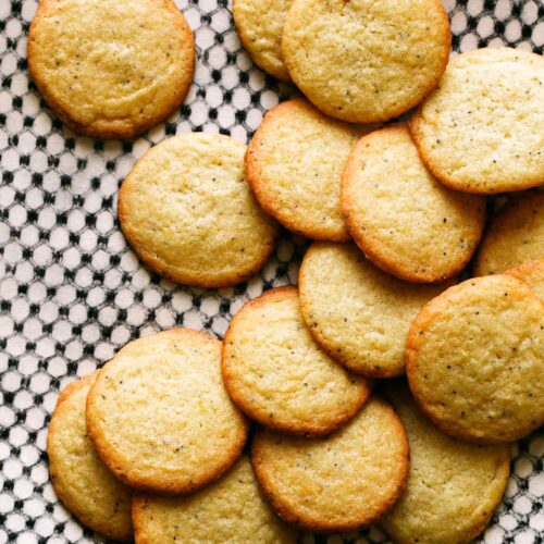 Pile of chewy lemon cookies on black and white plate.