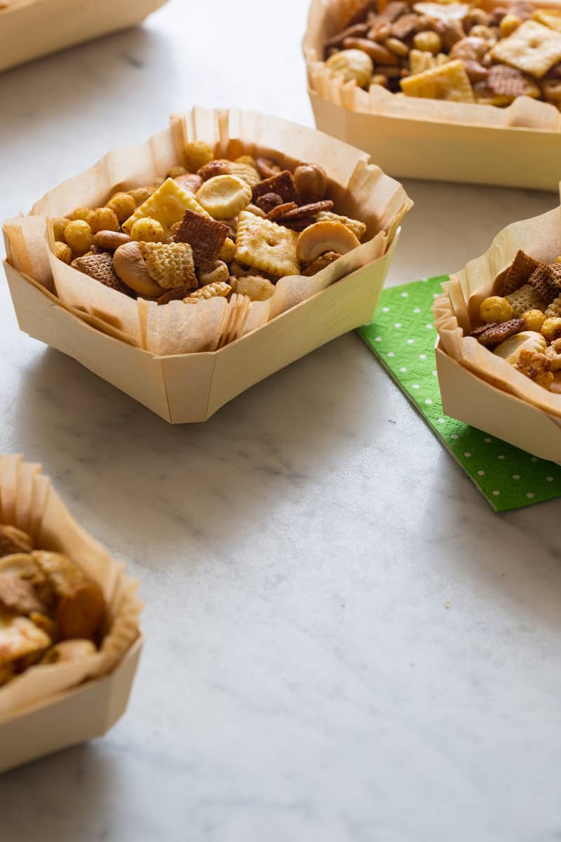 Snack mix in some bowls with napkins next to it.