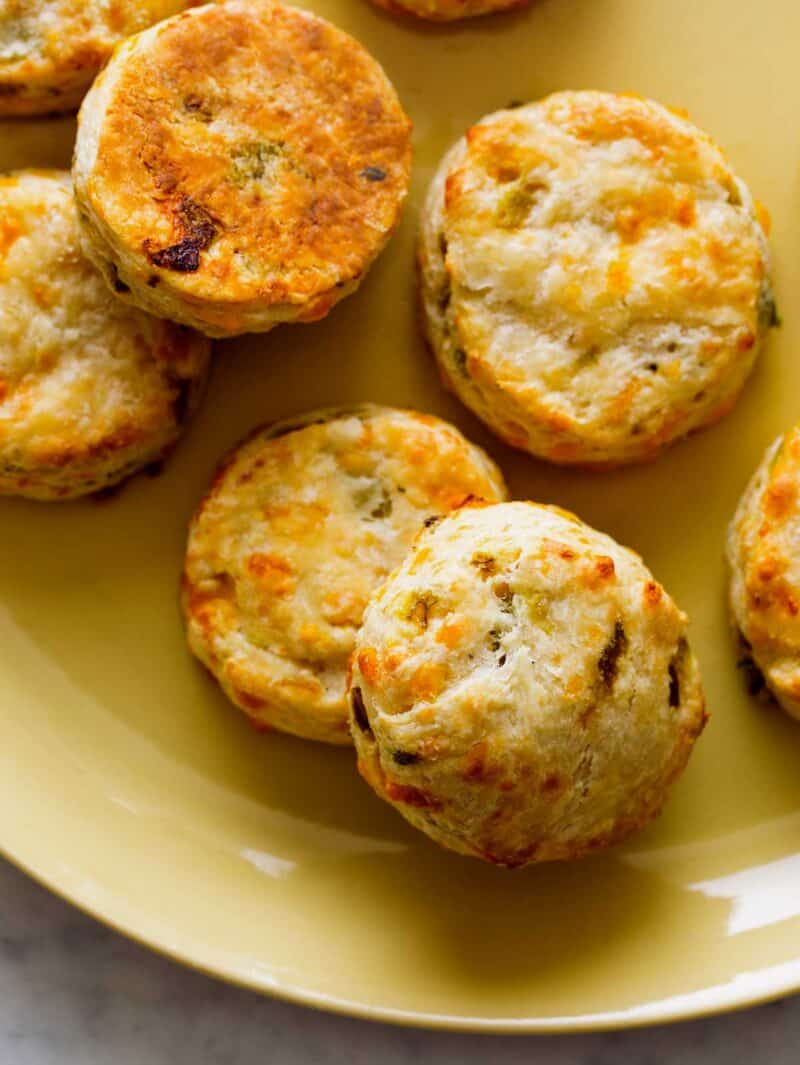 A close up of roasted hatch and cheddar biscuits on a yellow plate.