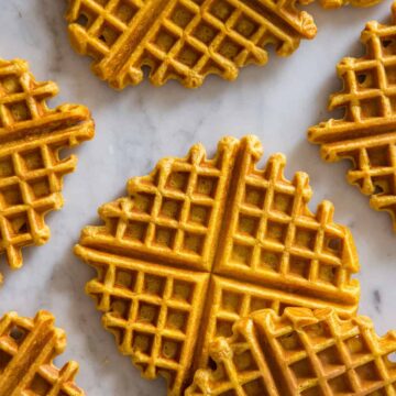 Pumpkin spiced waffles laid out on a marble kitchen counter.