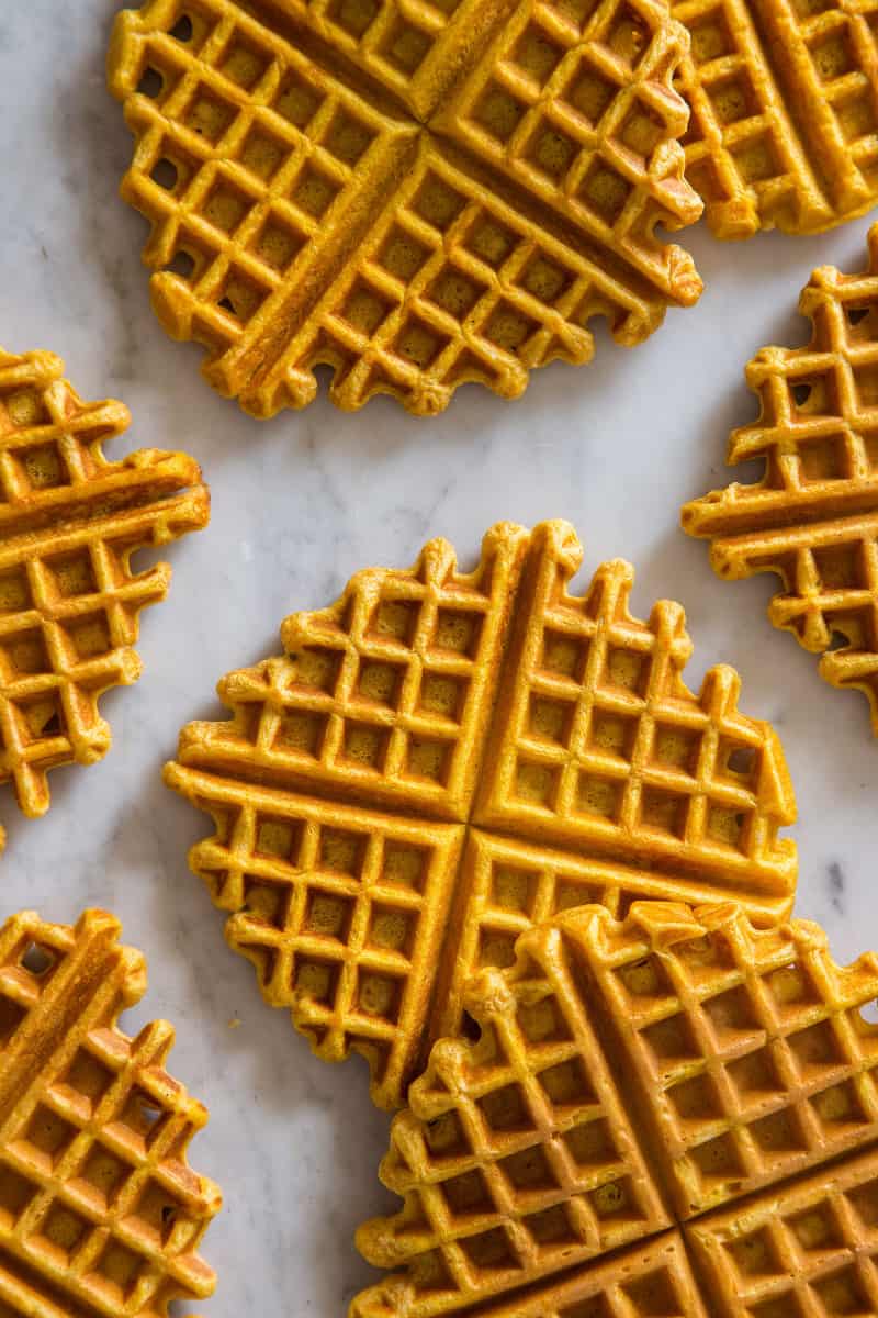 Pumpkin spiced waffles laid out on a marble kitchen counter.