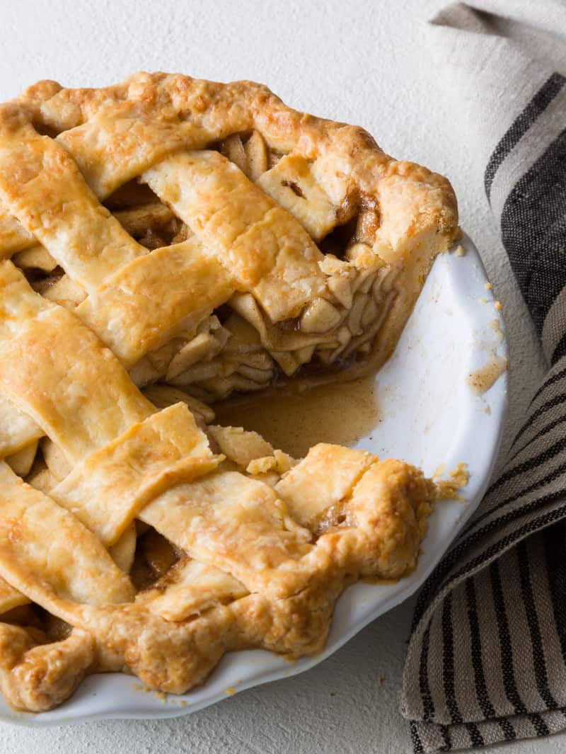 Browned butter apple pie with a slice taken out and a napkin next to it. 