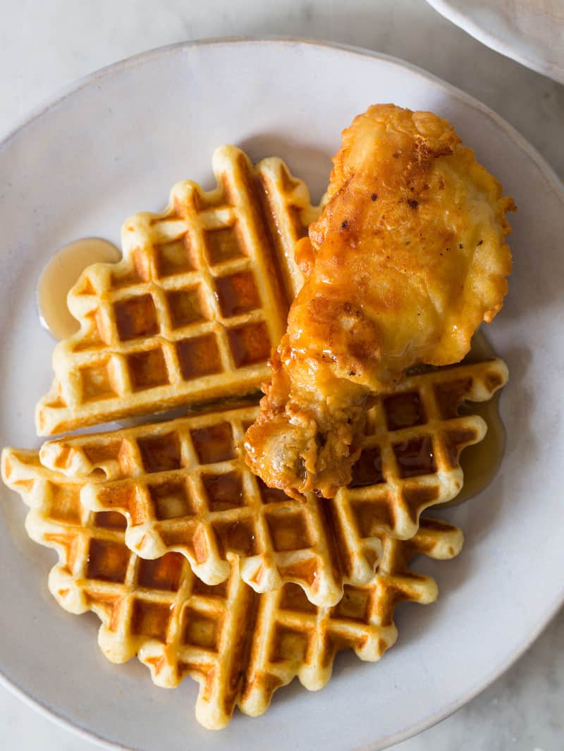 Fried chicken and waffles with syrup on a plate.