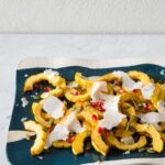 A turquoise and white platter of honey roasted delicata squash.