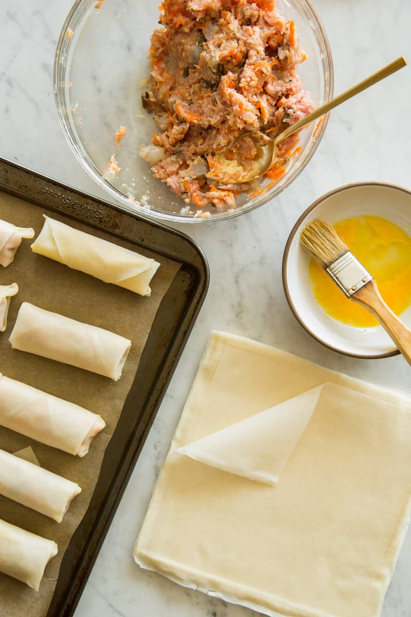 Vietnamese style pork and shrimp egg rolls with spring roll wrappers, filling, and beaten eggs.