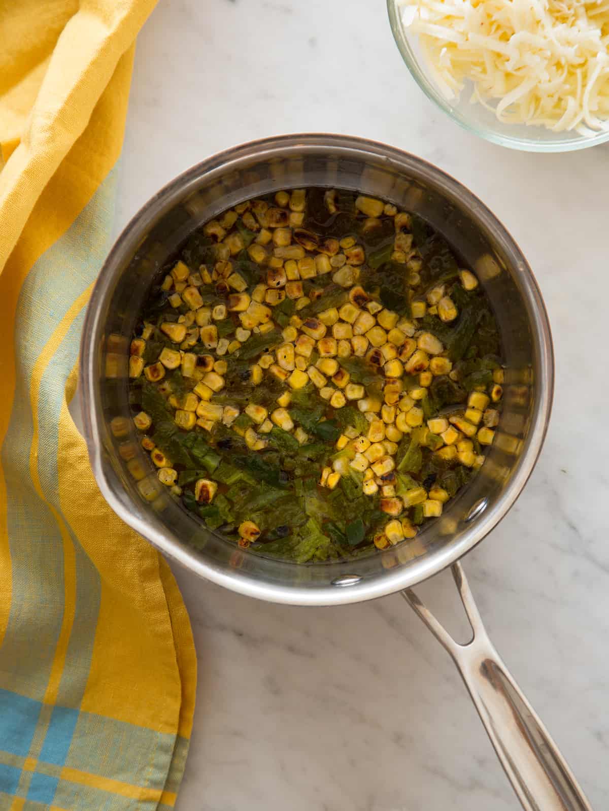 A pan of roasted poblano queso fondido ingredients before adding the cheese.