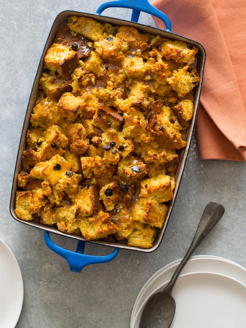 A baking dish of Irish Soda Bread Pudding with some plates on the side. 