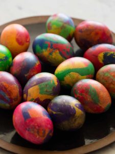 A plate of colorful painterly dyed Easter eggs.