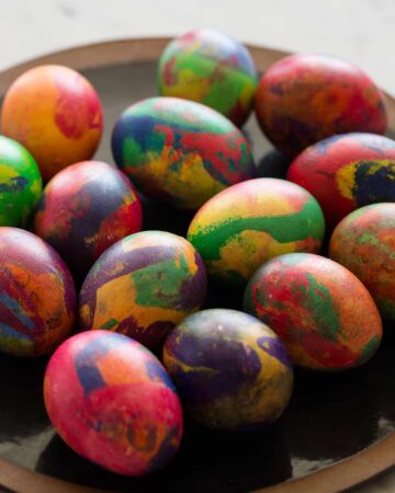 A plate of colorful painterly dyed Easter eggs.
