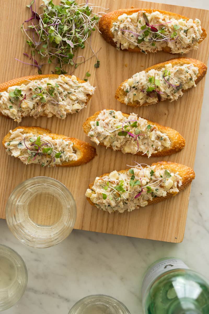 Smoked trout appetizer on crostinis on a cutting board. 