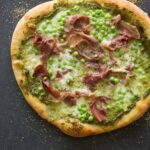 A whole English pea, prosciutto, and burrata pizza.