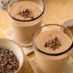 A close up of chocolate peanut butter and cinnamon smoothies in glasses with garnish.