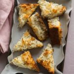 Several triangle cut pieces of coconut oat bars in a pan.