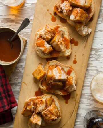 Crispy grilled pork belly with sweet and tangy vinegar BBQ sauce on bread.