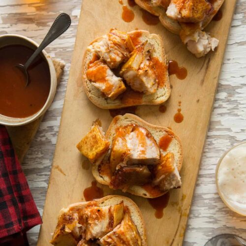 Crispy grilled pork belly with sweet and tangy vinegar BBQ sauce on bread.