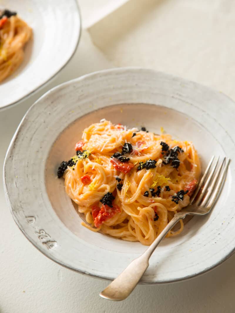 Capellini with smoked cream sauce in a bowl with a fork next to it. 