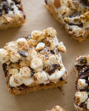 Close up on a slice of S'mores Rice Krispies treats on a piece of parchment.