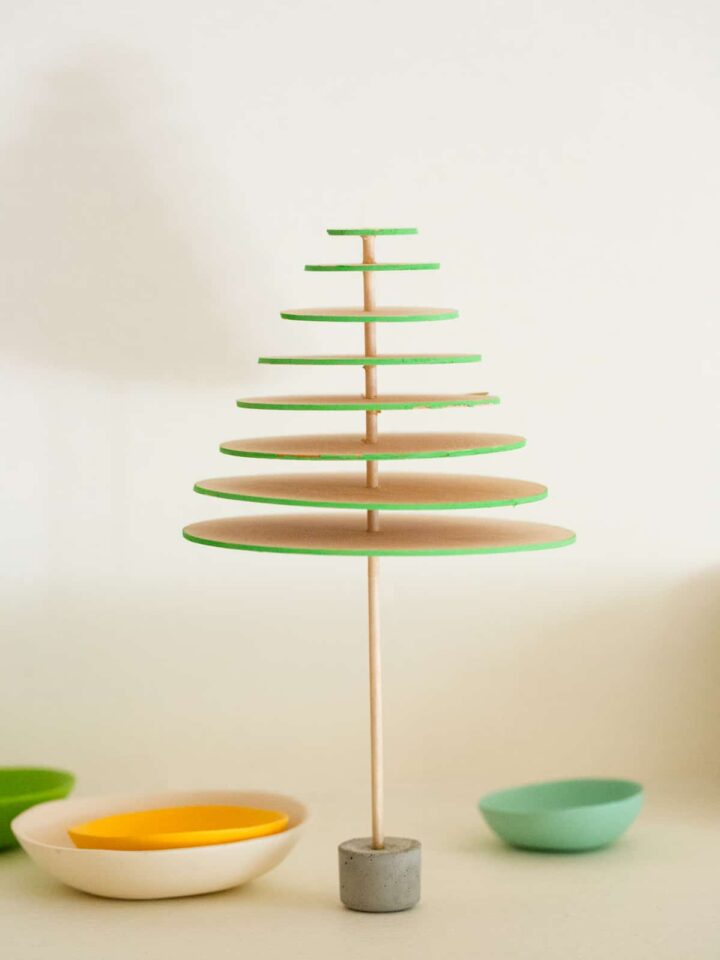 A DIY modern mini balsa wood Christmas tree with small bowls below.