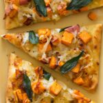 A close up of slices of sweet potato and caramelized onion flatbread.