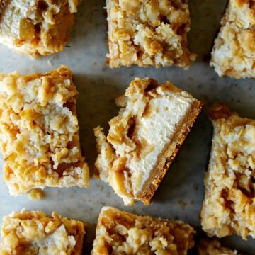 Individual streusel topped apple pie cheesecake bars.