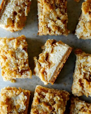 Individual streusel topped apple pie cheesecake bars.